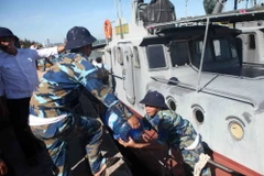 Vận chuyển nước lên tàu HQ211 để tiếp tế ra cho lực lượng tìm kiếm trên biển. (Ảnh: Thanh Tùng/TTXVN)