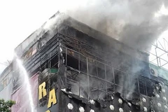 Tầng 3 quán karaoke bốc cháy nghi ngút. (Ảnh: Nguyễn Văn Trình/Vietnam+)