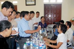 Bà Lê Thị Tám (người phụ nữ áo trắng, ngồi) đang "kiểm nghiệm" nước cho các hộ dân ở xã Quyết Thắng, thành phố Thái Nguyên.