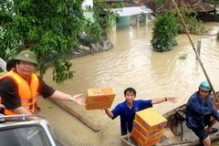 Cứu trợ cho người dân vùng ngập lũ. (Ảnh: Viết Ý/TTXVN)