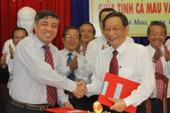 Tổng giám đốc TTXVN Trần Mai Hưởng (trái) và Chủ tịch Ủy ban Nhân dân tỉnh Cà Mau Bùi Công Bửu ký thỏa thuận. (Ảnh: Tràng Dương/TTXVN) 