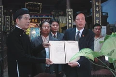 Nhà nghiên cứu Phan Thuận An (trái) trao tờ châu bản cho ông Phan Tiến Dũng, Giám đốc Sở VH,TT&DL tỉnh Thừa Thiên-Huế. (Ảnh: TT&VH)