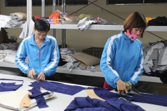 Cắt tạo mẫu cho sản phẩm may thời trang. (Ảnh: Hoàng Nguyên/TTXVN)