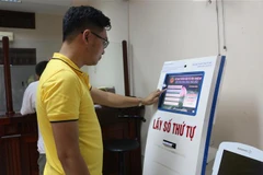 Lấy số thứ tự tự động có hình ảnh tại bộ phận một cửa Sở Giao thông Vận tải Nghệ An. (Ảnh: Bích Huệ/TTXVN)