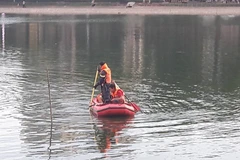 Cảnh sát nỗ lực tìm kiếm thi thể nam thanh niên (Ảnh: PV/Vietnam+) 