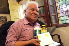 Tiến sỹ Khải và miếng xốp dùng để thực nghiệm hai loại dầu cá (Ảnh: Sơn Bách/Vietnam+) 