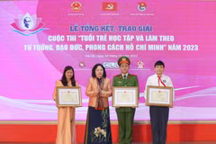 Thứ trưởng Bộ Giáo dục và Đào tạo Ngô Thị Minh trao bằng khen cho các tác giả đạt giải nhất. (Ảnh: Thanh Tùng/TTXVN)