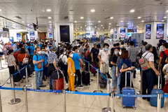 Hành khách làm thủ tục tại khu vực soi chiếu an ninh trước khi lên chuyến bay. (Ảnh: PV/Vietnam+)