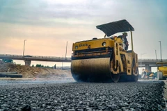 Nhà thầu tiến hành thi công thảm nhựa nền đường một tuyến Quốc lộ. (Ảnh: Minh Hiếu/Vietnam+)