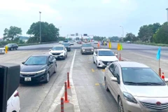 Xe xếp hàng dài lưu thông qua trạm thu phí tự động không dừng trên tuyến đường Cao tốc Nội Bài-Lào Cai. (Ảnh: PV/Vietnam+)
