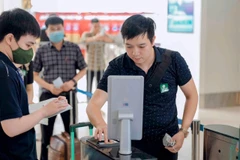 Hành khách sử dụng căn cước công dân gắn chíp để làm thủ tục đi máy bay. (Ảnh: PV/Vietnam+)