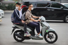 Tình trạng người điều khiển xe máy không đội mũ bảo hiểm, vi phạm an toàn giao thông vẫn còn diễn ra. (Ảnh: Hoài Nam/Vietnam+)