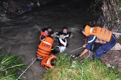 Lực lượng cứu hộ, cứu nạn tỉnh Đồng Nai đưa chiếc xe máy lên bờ và tiếp tục tham gia tìm kiếm người đàn ông mất tích do lũ cuốn trôi trong đêm. (Ảnh: Sỹ Tuyên/TTXVN)