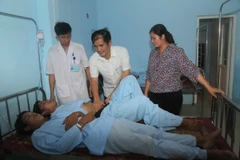 Lãnh đạo Ủy ban Nhân dân huyện Vị Xuyên thăm hỏi các bệnh nhân trong vụ ngộ độc. (Ảnh: Minh Tâm/TTXVN)