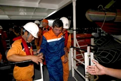 Đưa các thuyền viên gặp nạn lên bờ tại Đà Nẵng. (Ảnh: Trần Lê Lâm/Vietnam+)