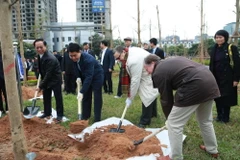 Chủ tịch Ủy ban Nhân dân thành phố Hà Nội Nguyễn Đức Chung và Đại sứ Phần Lan tại Việt Nam Kari Kahiluto tham gia trồng cây. (Ảnh: Nguyễn Cúc/TTXVN)
