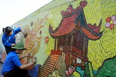 Các đoàn viên tham gia làm vệ sinh môi trường trên đoạn đường dài 3,8 km dọc theo con đường gốm sứ. (Ảnh: Đình Trân/TTXVN)