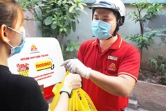 Nhân viên VISSAN giao hàng tận nhà cho khách hàng. (Ảnh: TTXVN phát)