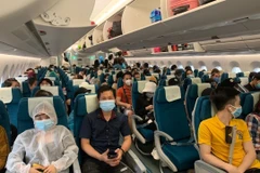 Các công dân Việt Nam trên tàu bay của Vietnam Airlines, chuẩn bị lên đường về nước. (Ảnh: Hà Ngọc/TTXVN)