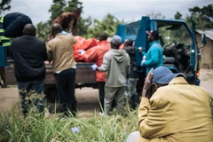 Chuyển nạn nhân thiệt mạng trong một vụ tấn công tại làng Manzalaho, gần Beni, CHDC Congo. (Ảnh: AFP/TTXVN)