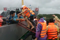 Những hành khách du lịch đầu tiên tại Cô Tô lên tàu để về đất liền chiều 30/7. (Ảnh: Thu Báu/TTXVN)