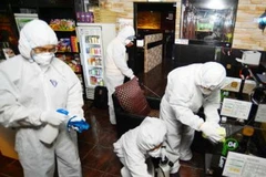 Nhân viên y tế phun thuốc khử trùng tại quán càphê ở Seoul phòng tránh sự lây lan của virus MERS. (Nguồn: AFP/TTXVN)