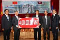 Đại sứ Nguyễn Mạnh Hùng trao quà tặng 40 tỷ đồng của Chủ tịch nước Trương Tấn Sang để xây dựng Nhà Văn hóa của tỉnh Luang Prabang. (Ảnh: Phạm Kiên/Vietnam+)