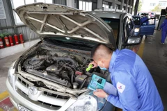 Nhân viên đăng kiểm thực hiện quy trình kiểm định xe cơ giới. (Ảnh: Minh Hiếu/Vietnam+)