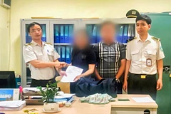 Anh Nguyễn Đức Tuệ và Đội trưởng Vũ Văn Diễn trao lại chiếc túi cho anh Trần Văn A và người nhà ngày 13/2 tại Cảng hàng không quốc tế Nội Bài. (Ảnh: CTV/Vietnam+)