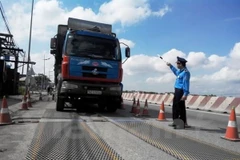Lực lượng chức năng tiến hành kiểm tra tải trọng xe. (Ảnh: Việt Hùng/Vietnam+)