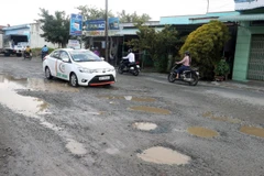 Một tuyến đường quốc lộ bị hư hỏng xuống cấp trầm trọng với những “ổ voi” sâu hoẵm, gây mất an toàn giao thông. (Ảnh: Lê Huy Hải/TTXVN)