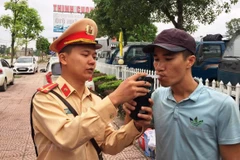 Cảnh sát giao thông tiến hành kiểm tra đo nồng độ cồn đối với lái xe. (Ảnh: Việt Hùng/Vietnam+)