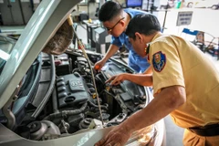 Cảnh sát giao thông và nhân viên đăng kiểm đang thực hiện quy trình kiểm định xe cơ giới. (Ảnh: CTV/Vietnam+)