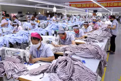 Một dây chuyền may gia công sản phẩm quần áo bảo hộ lao động và áo sơ mi xuất khẩu. (Ảnh: Vũ Sinh/TTXVN)