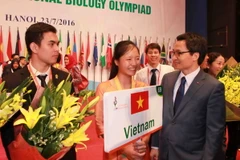Phó Thủ tướng Vũ Đức Đam tặng hoa chúc mừng thành tích của thí sinh đoàn Việt Nam. (Ảnh: Quý Trung/TTXVN)