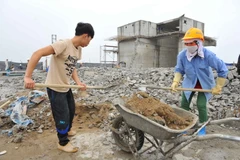 Thực hiện phá dỡ phần công trình xây dựng sai phạm tại tòa nhà 8B Lê Trực vào sáng 6/3 vừa qua. (Ảnh: Minh Đức/ TTXVN)