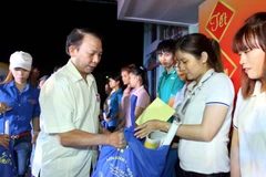 Tặng vé xe và quà cho công nhân về quê đón Tết Bính Thân 2016. (Ảnh: Thanh Vũ/TTXVN)