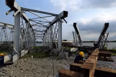 Hạng mục dầm cầu và 3 nhịp cầu Ghềnh đang được lắp ráp tại bãi lắp ráp ở thành phố Biên Hòa, sau đó sử dụng cần cẩu siêu trọng vận chuyển bằng đường thủy rồi ráp vào các mố cầu Ghềnh. (Ảnh: Huy Hùng/TTXVN)