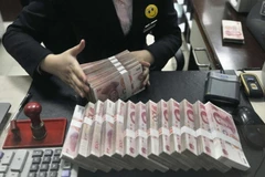 Kiểm đồng nhân dân tệ tại một ngân hàng ở Trung Quốc. (Ảnh: Reuter/TTXVN)
