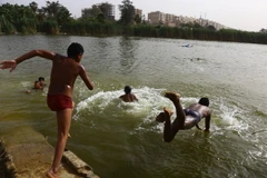 Trẻ em tắm mát trên sông Nile ở thủ đô Cairo, Ai Cập để tránh nắng nóng ngày 15/5 vừa qua. (Ảnh: THX/TTXVN)