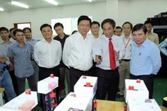 Bí Thư Thành ủy TP Hồ Chí Minh Đinh La Thăng cùng Chủ tịch UBND TP Hồ Chí Minh Nguyễn Thành Phong đến thăm và làm việc tại Đại học Quốc gia TP Hồ Chí Minh. (Ảnh: Thanh Vũ/TTXVN)