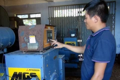 Công nhân khởi động máy phát điện chạy dầu diesel trên đảo Cù Lao Chàm. (Ảnh: Đỗ Trưởng/TTXVN)