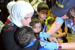 Cảnh sát Cộng hòa Séc chăm sóc những người nhập cư. (Nguồn: thesun.co.uk)