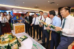 Các đại biểu xem các sản phẩm trưng bày tại triển lãm. (Ảnh: Hoàng Hiếu/TTXVN)