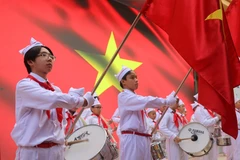 Đội hồng kỳ trên sân khấu, đội trống đánh lên những nhịp đều đặn, vang dội. (Ảnh: Minh Anh/Vietnam+)