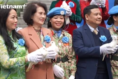 Các đại biểu, khách mời tại tọa đàm thả chim bồ câu, tượng trưng cho khát vọng hòa bình. (Ảnh: PV/Vietnam+)