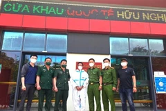 Các lực lượng chức năng tiếp nhận đối tượng truy nã đặc biệt Thào Mí Say (giữa) do Trung Quốc trao trả qua Cửa khẩu Quốc tế Hữu nghị (Lạng Sơn). (Ảnh: Nguyễn Lân/TTXVN phát)