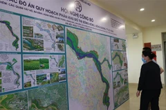 Người dân xem đồ án quy hoạch sông Đuống tỷ lệ 1/5.000. (Ảnh Mạnh Khánh/TTXVN)