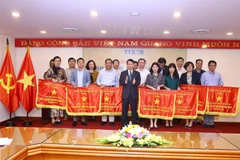 Ủy viên Trung ương Đảng, Bí thư Đảng ủy, Tổng giám đốc TTXVN Nguyễn Đức Lợi tặng Cờ thi đua của TTXVN cho 21 tập thể. (Ảnh: Minh Quyết/TTXVN)