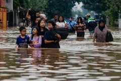 Sơ tán người dân khỏi khu vực ngập lụt sau mưa lớn tại làng Dayeuhkolot ở Bandung, Tây Java, Indonesia. (Nguồn: AFP/TTXVN)